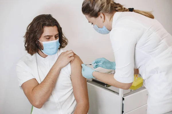 Vrouwelijke arts geeft een vaccin aan patiënten — Stockfoto