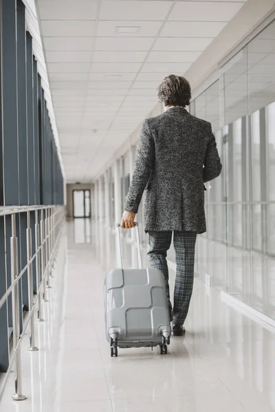 Senior Geschäftsmann mit Reisekoffer im Flughafen — Stockfoto