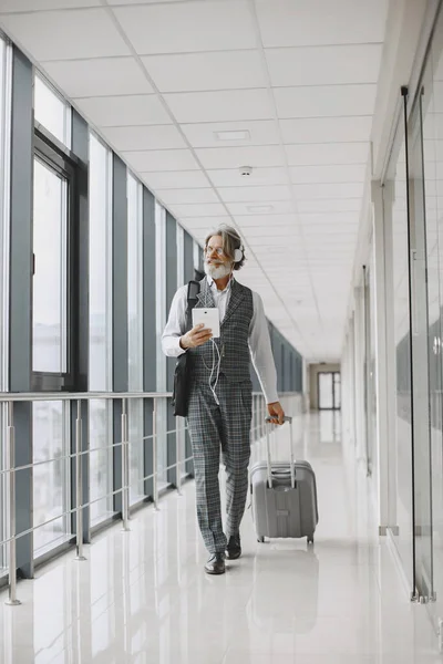 Senior businessman with travel suitcase in airport — Stock Photo, Image