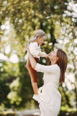 Anne ve küçük kızı bir yaz parkında oynuyorlar.