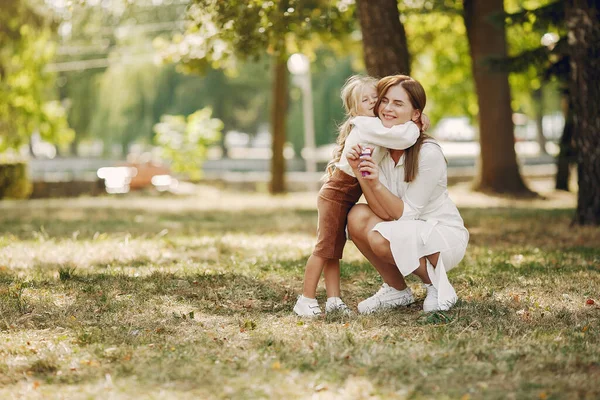 Мать с маленькой дочерью играет в летнем парке — стоковое фото