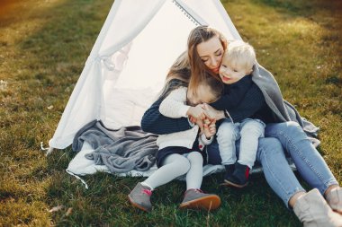 Anne ve çocuklar yaz parkında oynuyorlar.