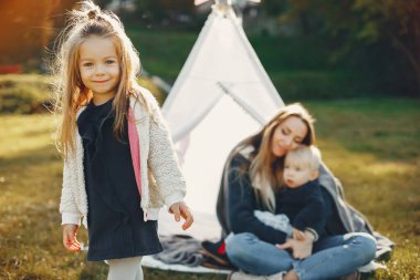 Anne ve çocuklar yaz parkında oynuyorlar.