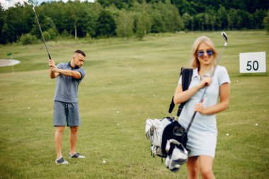 Golf sahasında golf oynayan güzel bir çift.