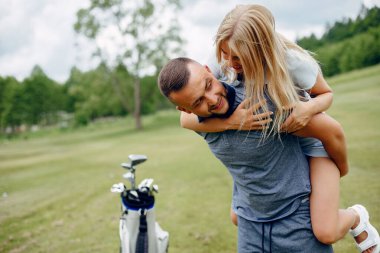 Golf sahasında golf oynayan güzel bir çift.