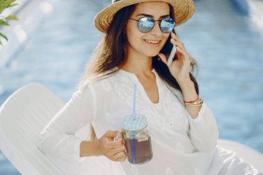 Çekici kız havuzun güneşli havasını seviyor.