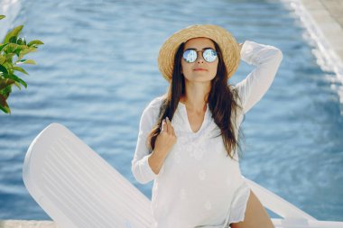 Çekici kız havuzun güneşli havasını seviyor.