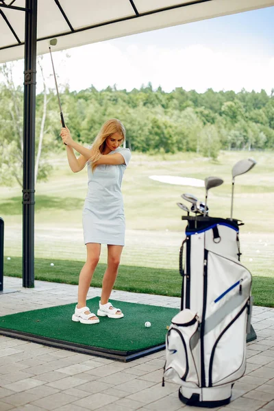 Krásná dívka hraje golf na golfovém hřišti — Stock fotografie