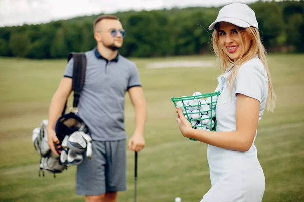 Krásný pár hraje golf na golfovém hřišti — Stock fotografie