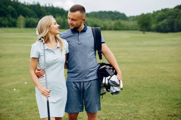 Piękna para grająca w golfa na polu golfowym — Zdjęcie stockowe