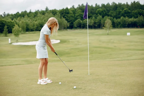 Krásná dívka hraje golf na golfovém hřišti — Stock fotografie
