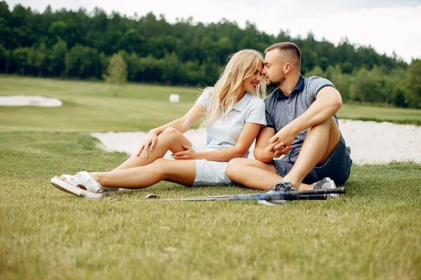 Belo casal jogando golfe em um campo de golfe — Fotografia de Stock