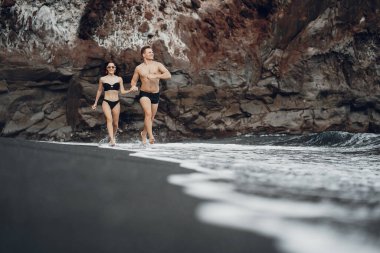 Sahilde kayaların yanında zarif bir çift.