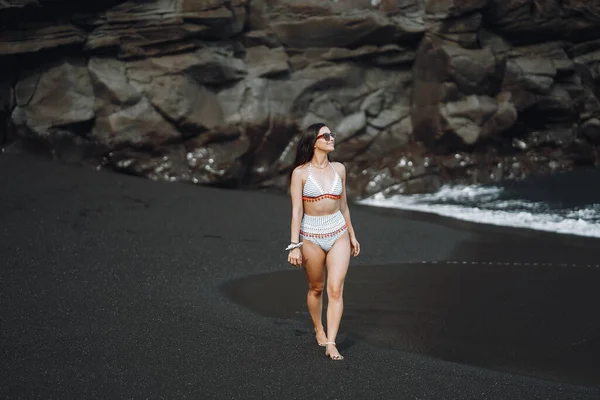 La ragazza in un costume da bagno elegante ha un riposo n una spiaggia — Foto Stock