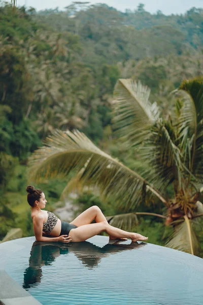 Mulher em uma piscina em uma vista da selva — Fotografia de Stock