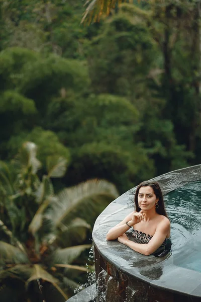 Vrouw in een zwembad op een jungle uitzicht — Stockfoto
