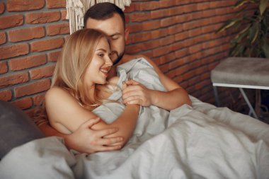 Odada bir yatakta oturan çift.