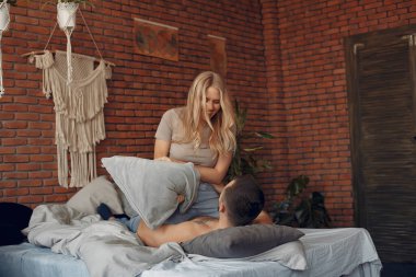 Odada bir yatakta oturan çift.