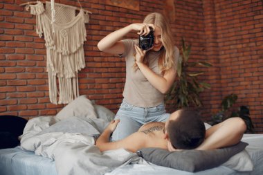 Odada bir yatakta oturan çift.