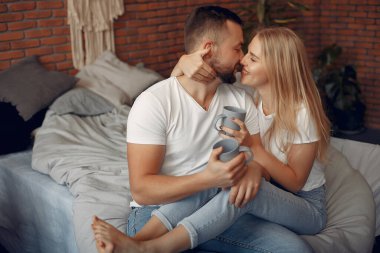 Odada bir yatakta oturan çift.