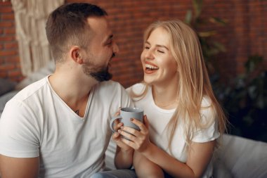 Odada bir yatakta oturan çift.