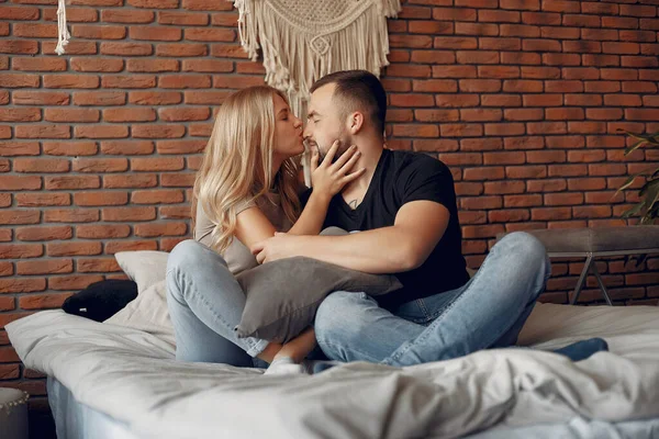 Paar sitzt auf einem Bett in einem Zimmer — Stockfoto