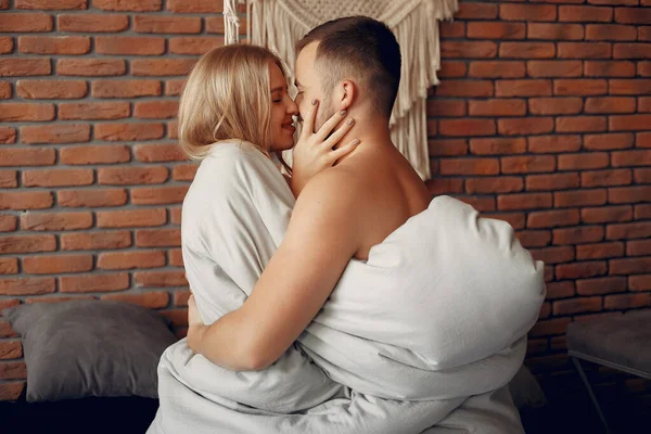 Casal sentado em uma cama em um quarto — Fotografia de Stock