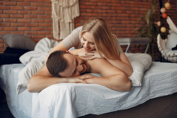 Casal sentado em uma cama em um quarto — Fotografia de Stock