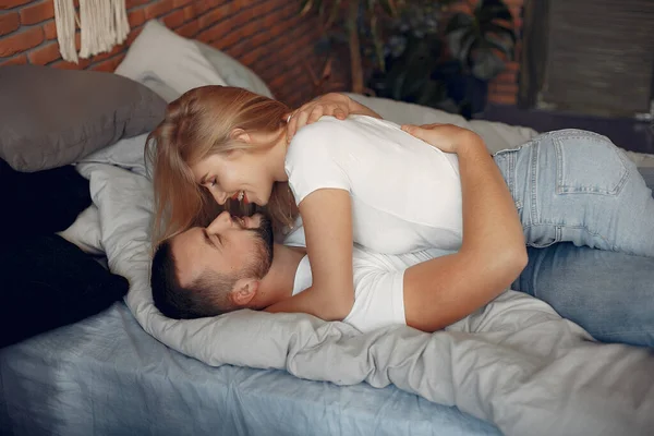 Casal sentado em uma cama em um quarto — Fotografia de Stock