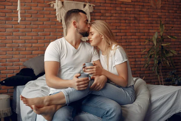 Casal sentado em uma cama em um quarto — Fotografia de Stock