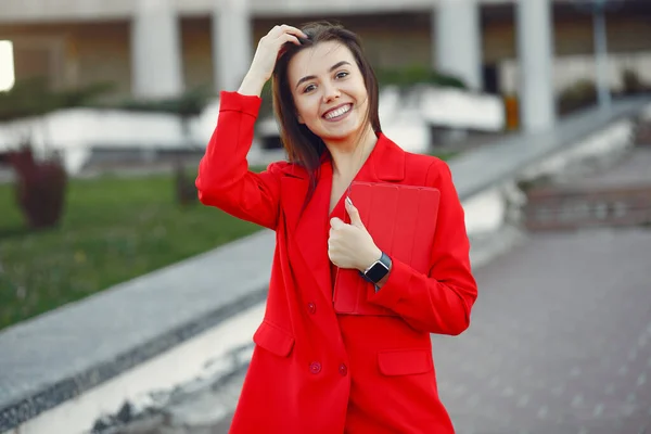 Vrouw in rood jasje gebruik een tablet — Stockfoto