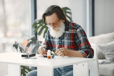 Erkek teknisyen evde elektronik ekipman tamir ediyor.