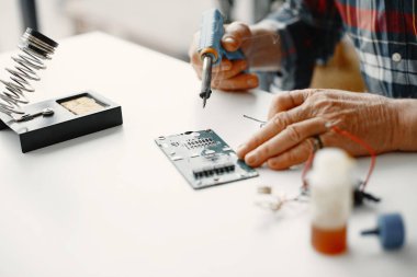 Erkek teknisyen evde elektronik ekipman tamir ediyor.