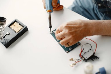 Erkek teknisyen evde elektronik ekipman tamir ediyor.