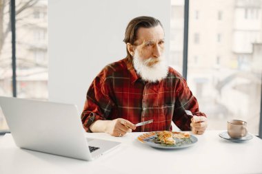 Son sınıf öğrencisi mutfakta yemek yiyor.