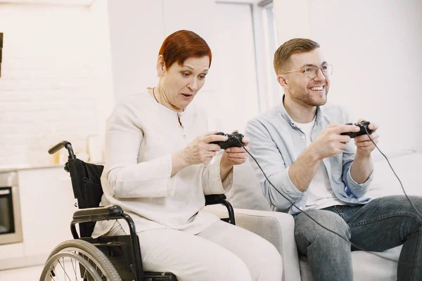 Senior discapacitada mujer jugar videojuegos con hijo — Foto de Stock