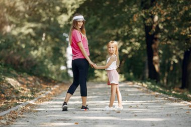 Anne ve kızı yaz parkında oynuyorlar.