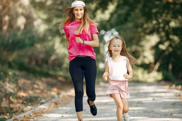 Madre con figlia che fa sport in un parco estivo — Foto Stock