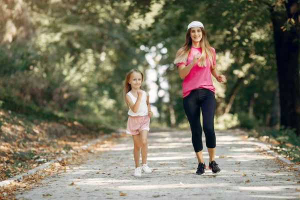 Mutter mit Tochter beim Sport im Sommerpark — Stockfoto