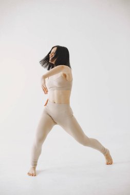 Stüdyoda dans eden güzel genç bir kadın.
