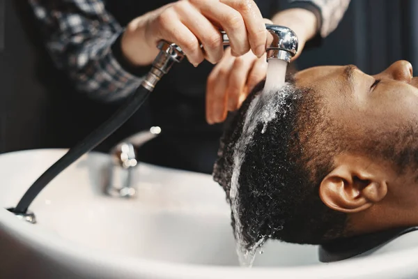 Junger afroamerikanischer Mann besucht Friseurladen — Stockfoto