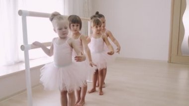 Küçük Afrikalı kız bale barında koreografik öğeler üzerinde pratik yapıyor.