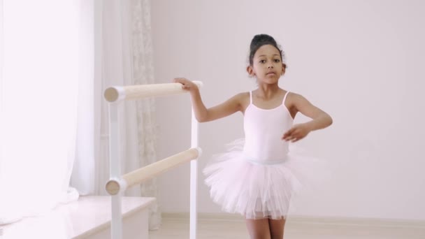 Pequena menina africana praticando elementos coreográficos no ballet barre — Vídeo de Stock