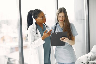 İki kadın doktor bir belgeye bakıyor.