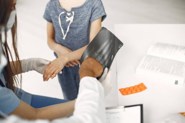 Doktor küçük bir kızı hastanede muayene ediyor.