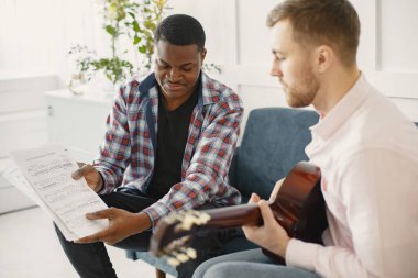 Gitar çalan Afrikalı ve beyaz adam.