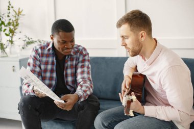 Gitar çalan Afrikalı ve beyaz adam.