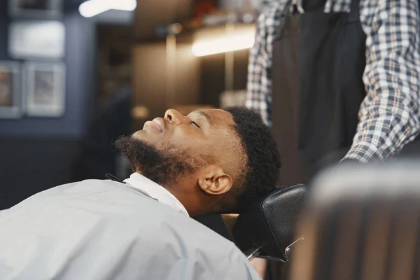 Jovem afro-americano visitando barbearia — Fotografia de Stock