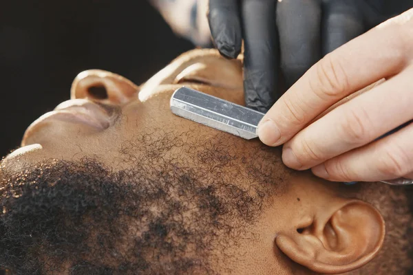 Jovem afro-americano visitando barbearia — Fotografia de Stock