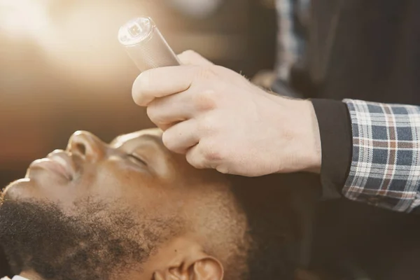 Jovem afro-americano visitando barbearia — Fotografia de Stock